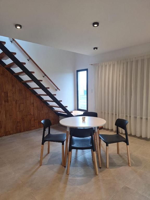 a table and chairs in a room with a staircase at Duplex Frente mar in Playa Dorada