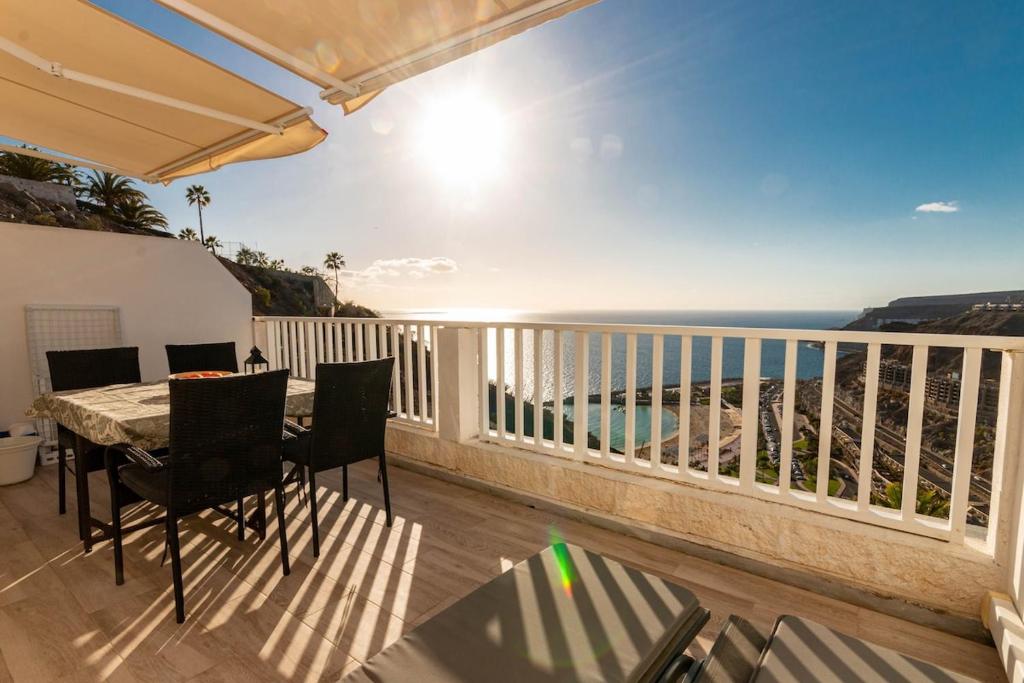 a balcony with a table and chairs and the ocean at Vista Calma Suite Puerto Rico in Puerto Rico de Gran Canaria