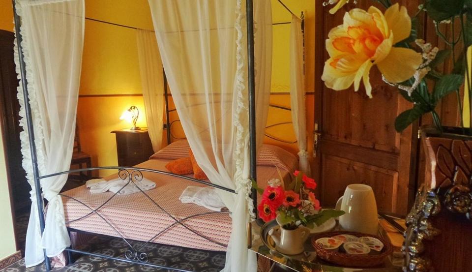 アレーツィオにあるAntica Dimoraのベッドルーム1室(ベッド1台、花のテーブル付)