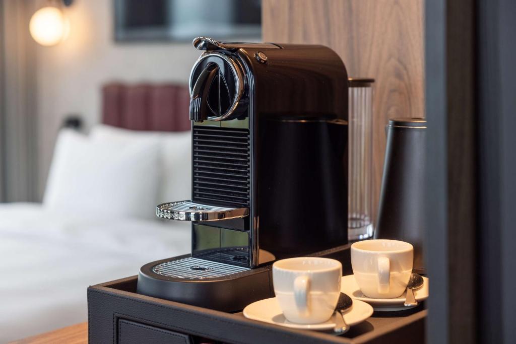 Příslušenství pro přípravu čaje a kávy v ubytování Radisson Blu Hotel at Porsche Design Tower Stuttgart