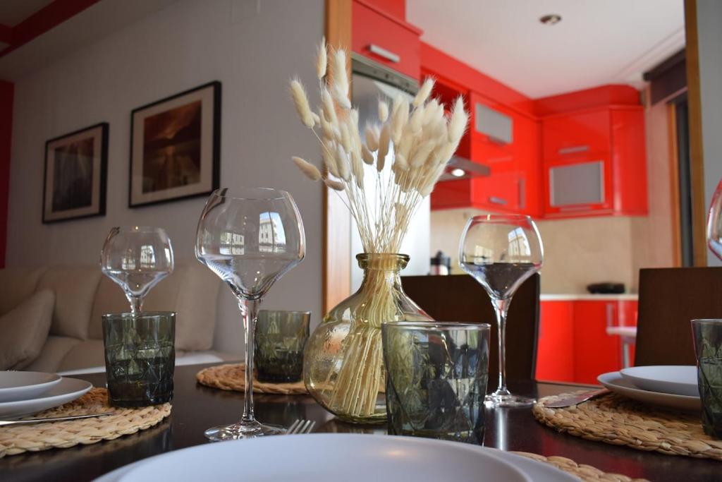 a table with wine glasses and a vase with flowers at Apartamento luminoso y acogedor in Salvatierra de Miño