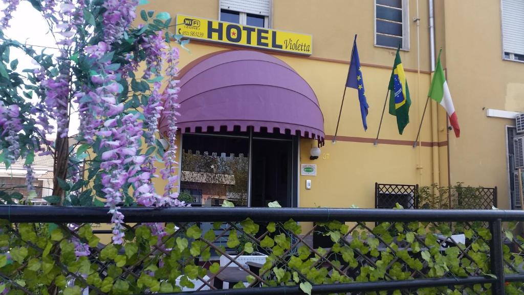 un hotel con toldo púrpura frente a un edificio en Hotel Violetta, en Parma