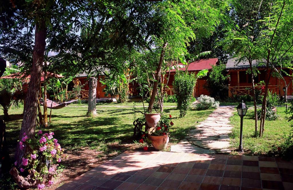 a walkway in a yard with trees and flowers at Myland Nature in Cıralı