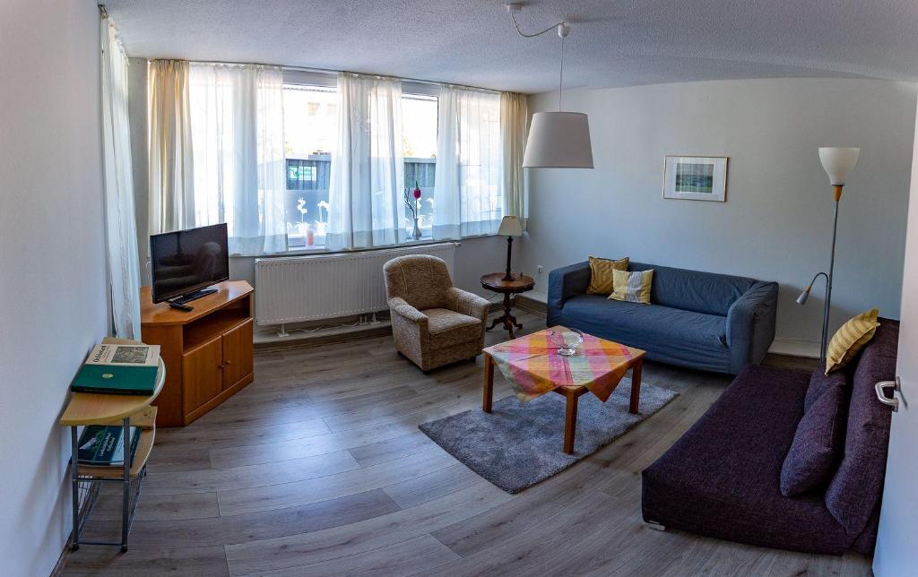 un soggiorno con un divano e un tavolo di Ferienwohnung-Krabbe a Dornum