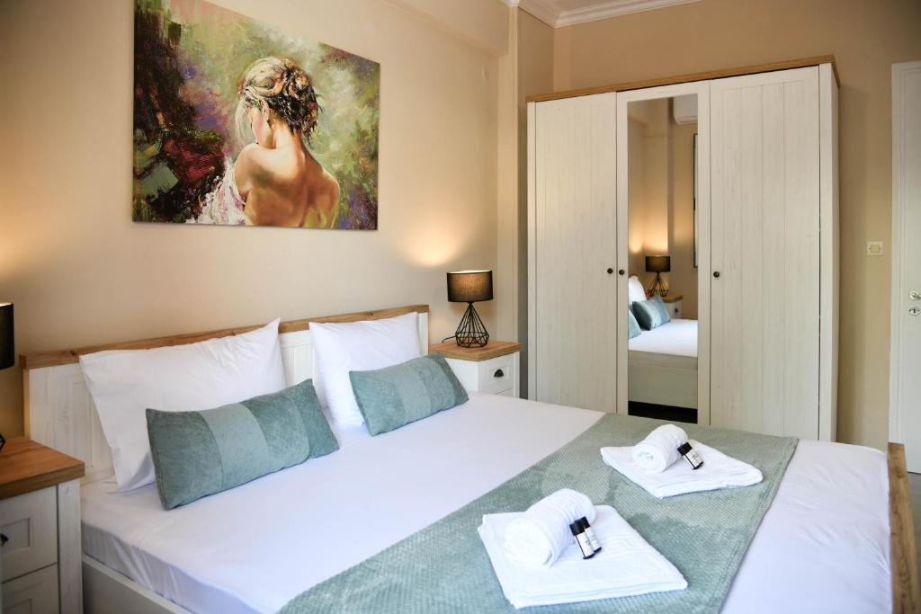 a bedroom with a large white bed with towels on it at Secret Yard Luxury Apartment in Anemómylos
