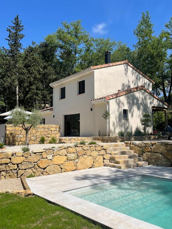 une maison avec un mur en pierre et une piscine dans l'établissement Villa with pool, absolute calm, à Plascassier