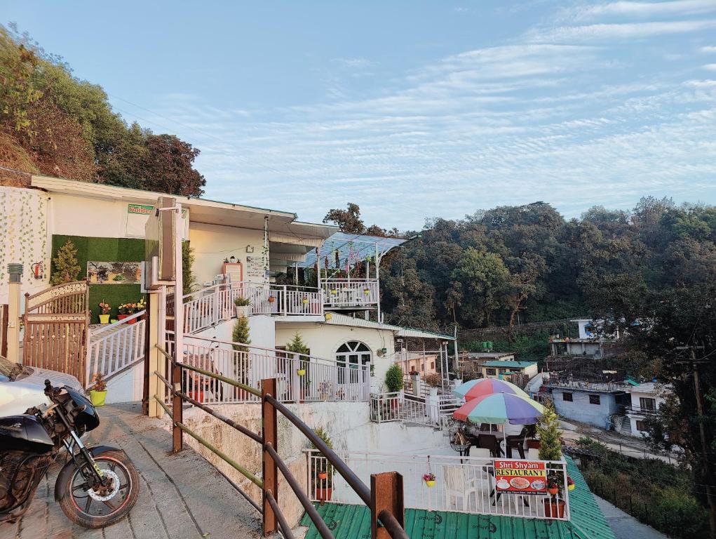 a motorcycle parked in front of a house with an umbrella at Golden Oak Villa Mussoorie in Rājpur
