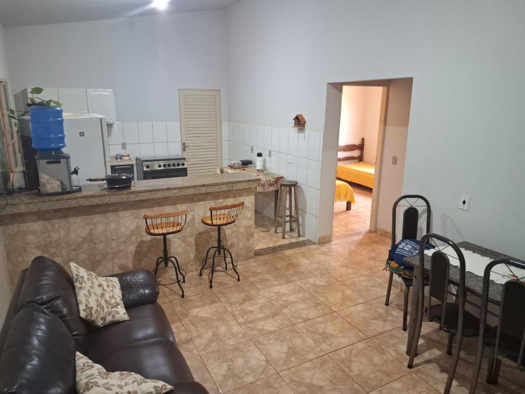 a living room with a couch and a kitchen at Sitio jardim da canastra in São Roque de Minas