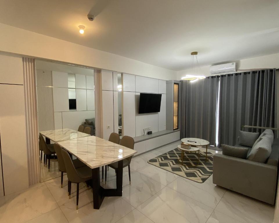 a living room with a dining table and a couch at Sky House BSD in Samporo