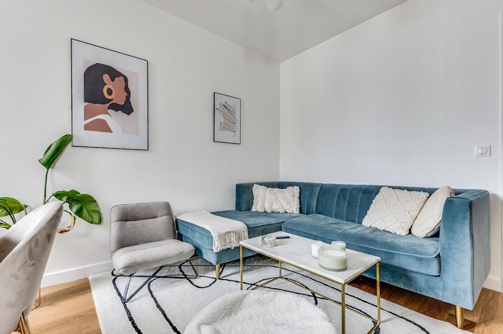 un salon avec un canapé bleu et une chaise dans l'établissement Intemporel, à Paris