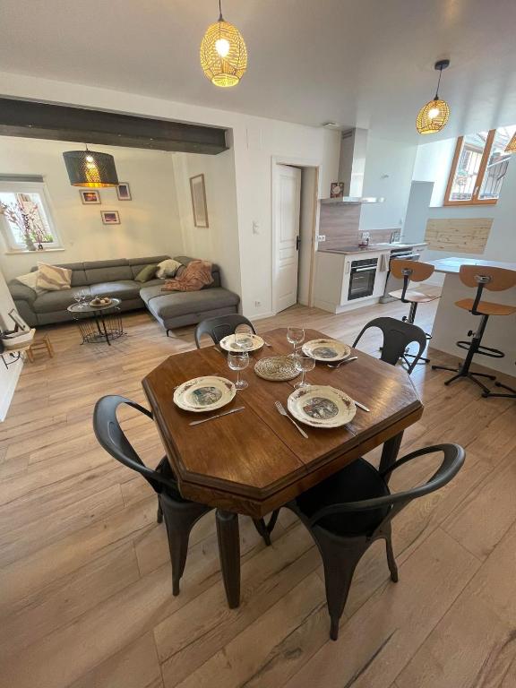 un salon avec une table et des chaises en bois dans l'établissement L'âme des Vignes Gîte Alsace, à Mittelbergheim