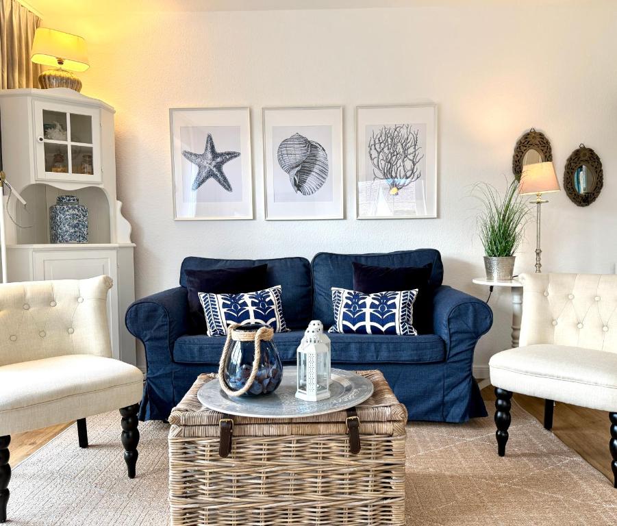 ザンクト・ペーター・オルディングにあるFrida SPO Ferienwohnung Nordsee mit Hundのリビングルーム(青いソファ、椅子2脚付)