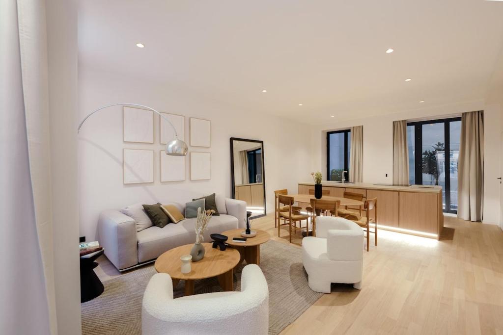 un salon avec un canapé, des chaises et une table dans l'établissement Large and Calm 2BR Apt with AC & Patio, à Paris