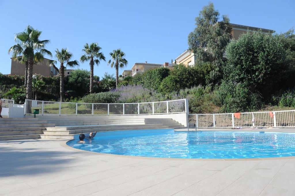 - une piscine avec un pont et des palmiers dans l'établissement Apartment in park with pool, à Cannes
