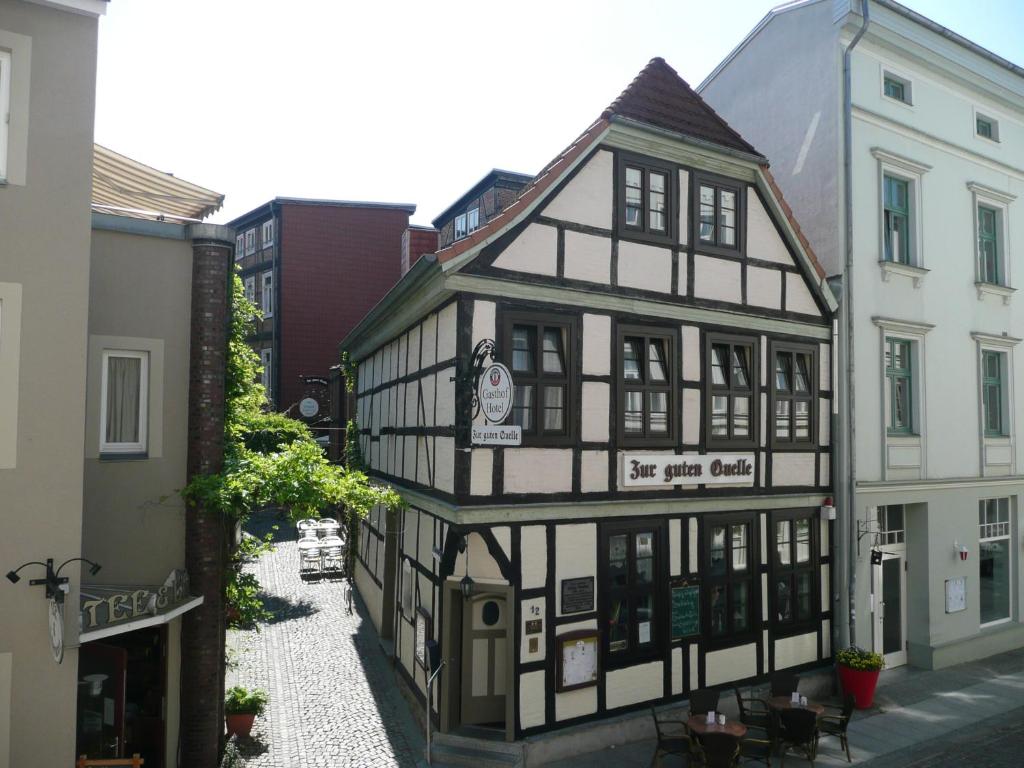 un vieux bâtiment noir et blanc dans une rue dans l'établissement Gasthof Zur guten Quelle, à Schwerin