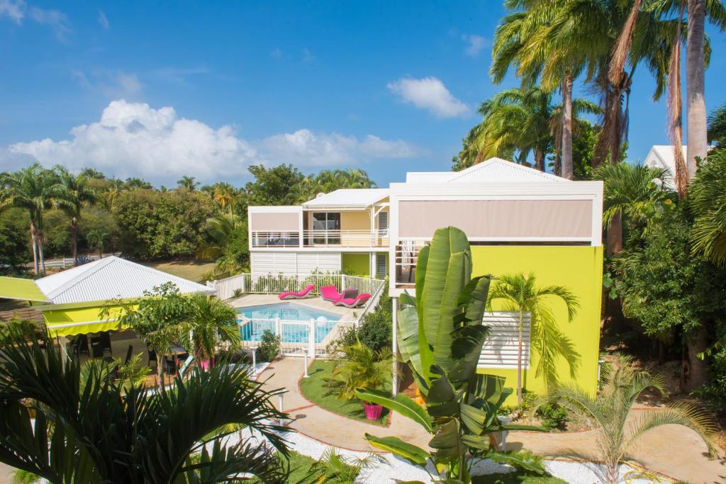 a view of a house with a pool and palm trees at Majesty Palm in Saint-François