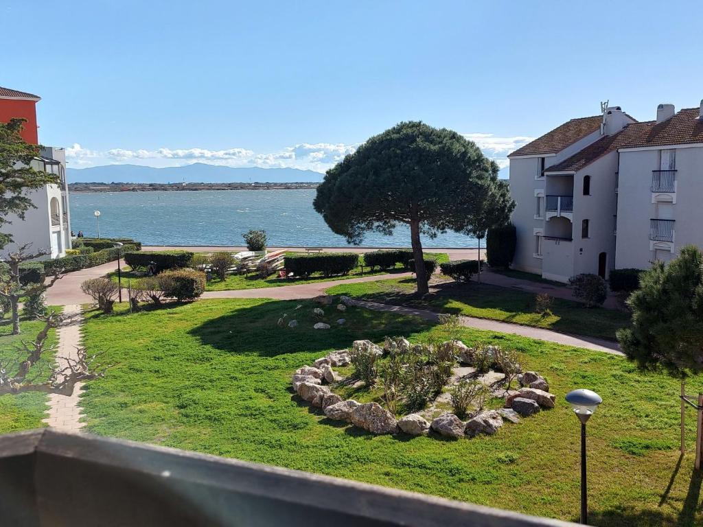 Elle offre une vue sur un parc avec un arbre et un jardin. dans l'établissement Apartment Dominica-2 by Interhome, au Barcarès