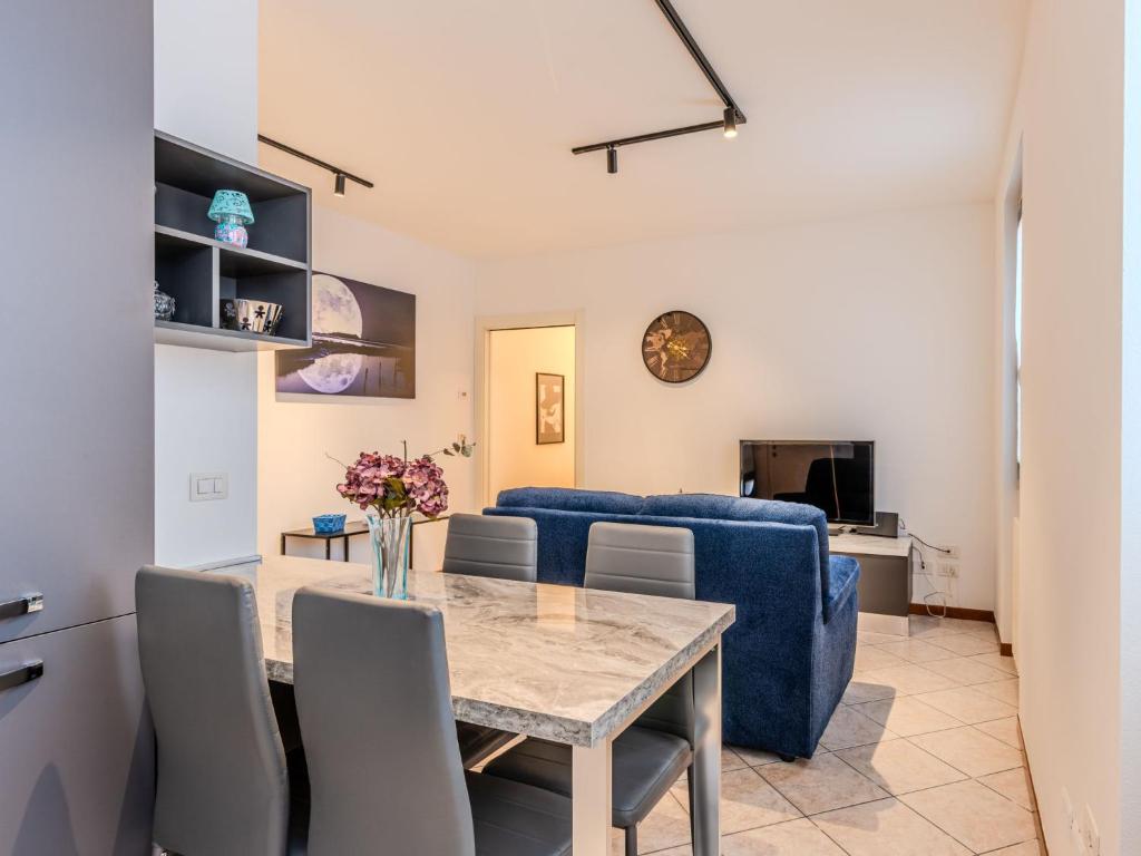 a living room with a table and a blue couch at Apartment Jai Jai by Interhome in Colico