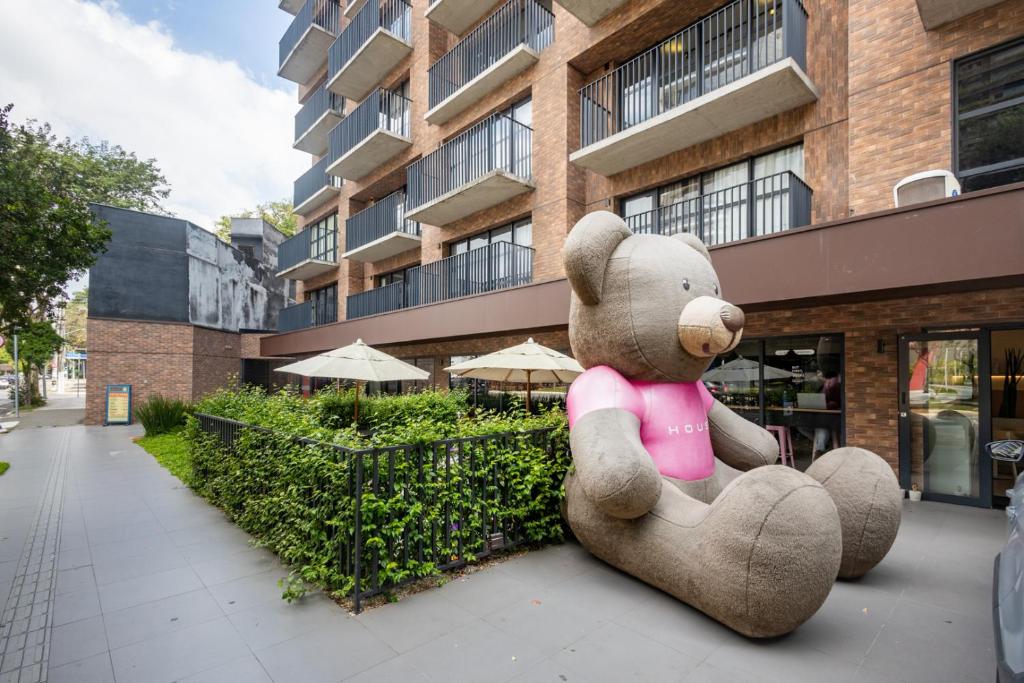a large teddy bear sitting in front of a building at Housi Faria Lima in Sao Paulo