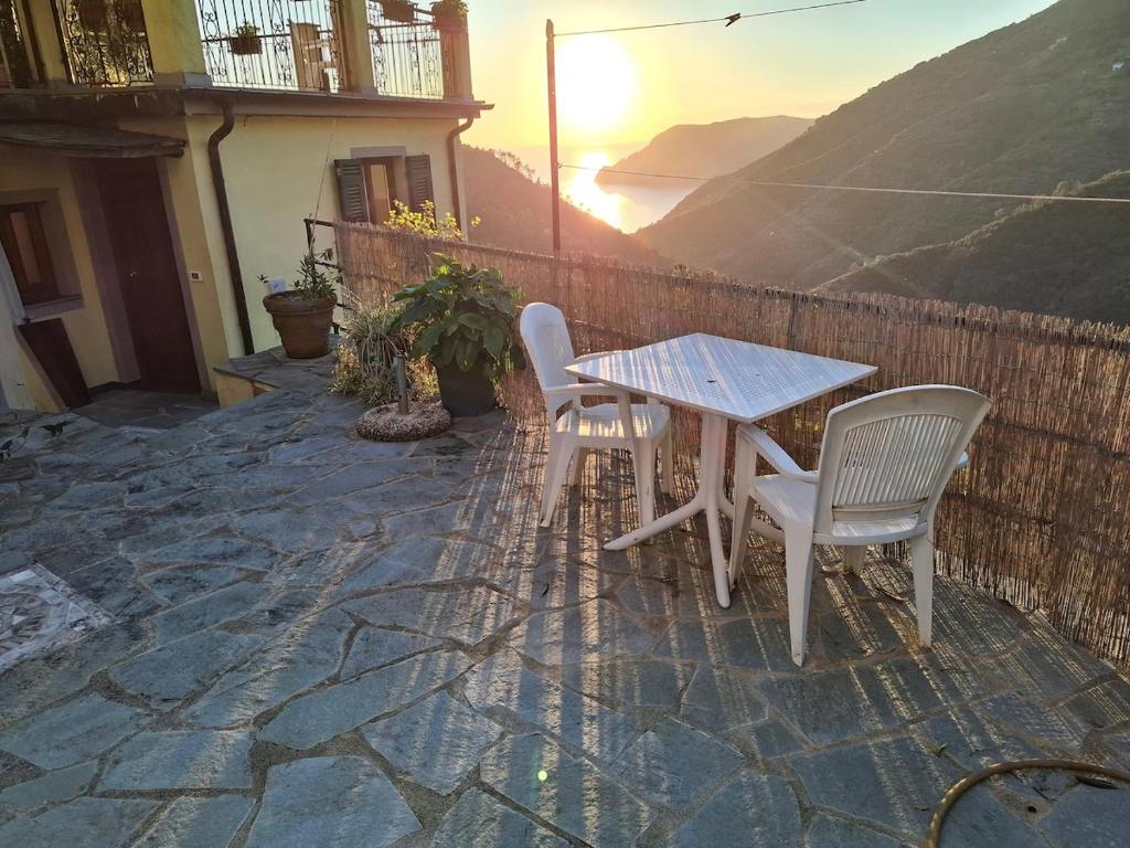 a table and chairs on a stone patio with the sunset at Il vigneto in Vernazza