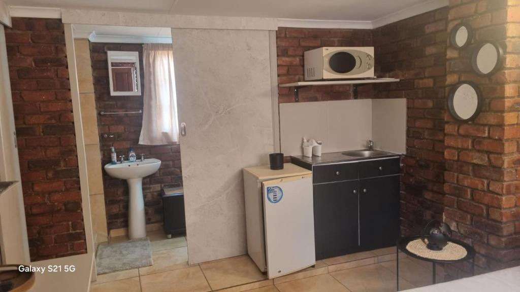 una piccola cucina con lavello e microonde di Eagles Rest a Klerksdorp