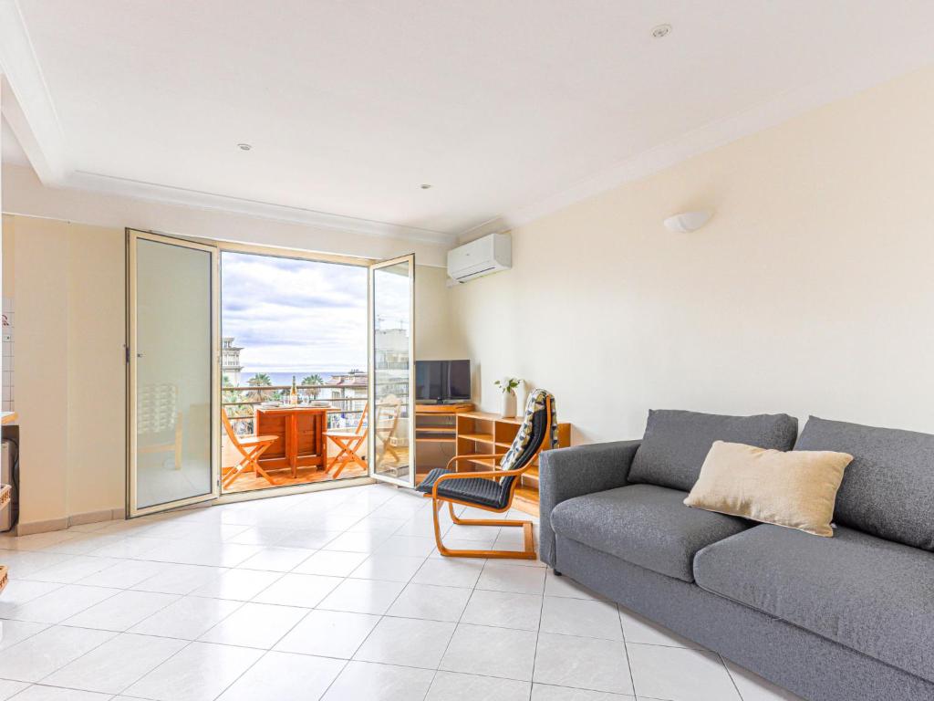 d'un salon avec un canapé et un balcon. dans l'établissement Apartment Le Mirazur by Interhome, à Nice