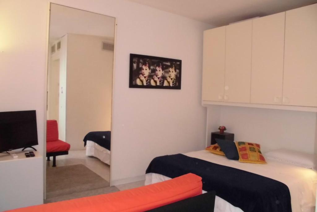 Una pequeña habitación con dos camas y un espejo. en Solo TUO, en Mestre