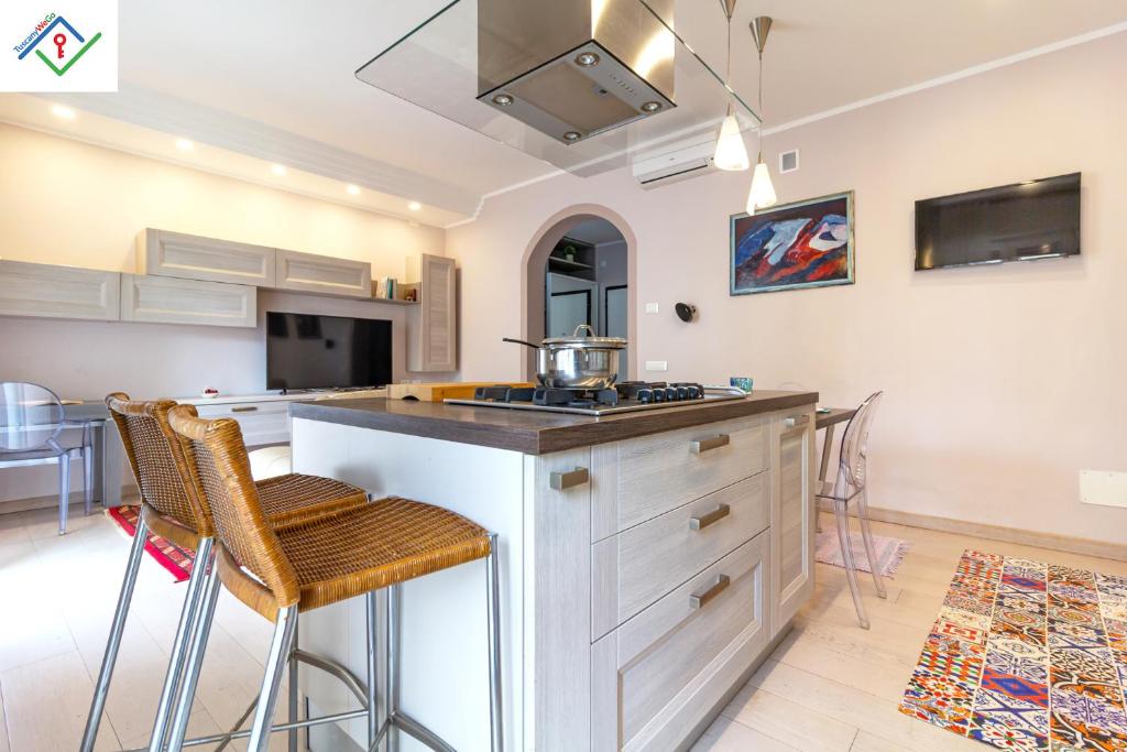 a kitchen with a sink and a counter with stools at A Casa Di Giò by TuscanyWeGo in Livorno
