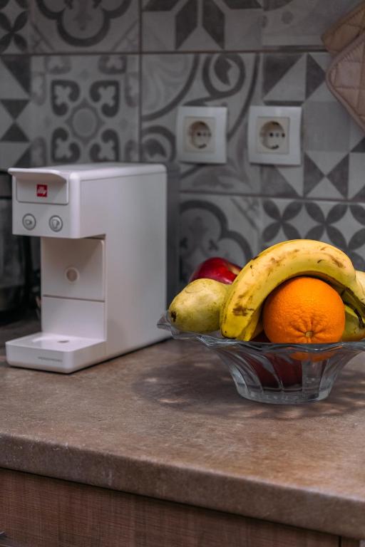 a bowl of fruit on a counter next to a microwave at Ioannina Center Apartment in Ioannina