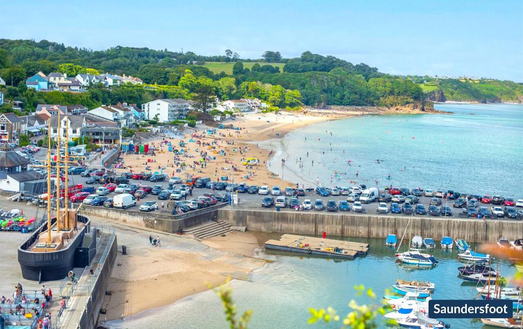een druk strand met een menigte mensen en boten bij Lilac Cottage in Tenby