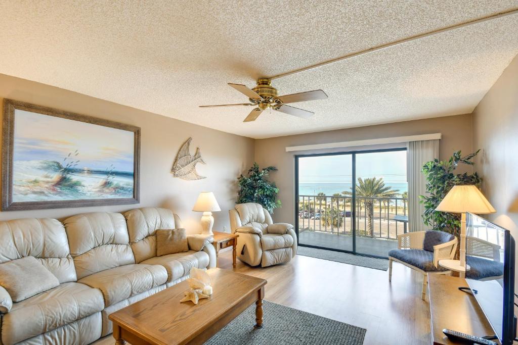 a living room with a couch and a ceiling fan at Walk to Madeira Beach Coastal Condo with Balcony in St Pete Beach