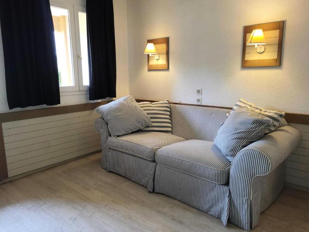 a living room with a couch and two windows at Résidence Saint-Raphaël Valescure - maeva Home - Studio 2 personnes - Sélection MAE-3141 in Valescure