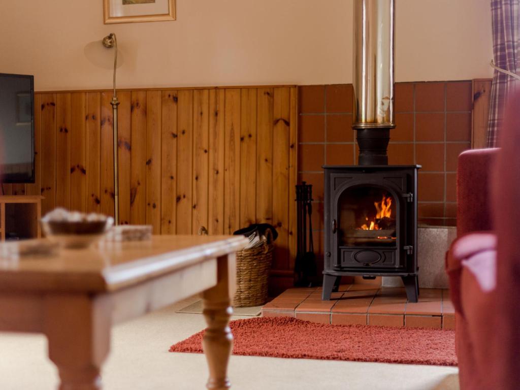 ein Wohnzimmer mit einem Holzofen in der Unterkunft Holiday Home Doonans Cottage by Interhome in Straiton