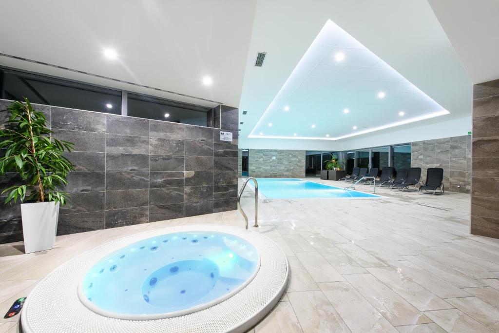 a large bathroom with a tub in the middle of a building at Sport Hotel in Dolní Morava