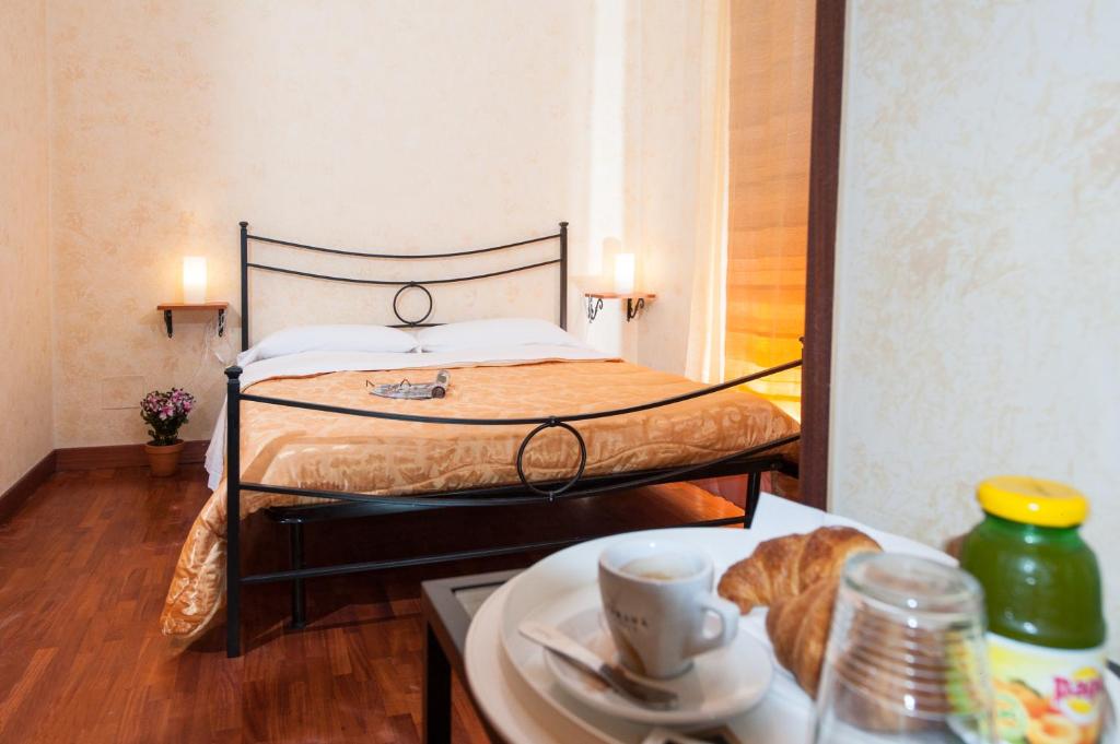 ein Schlafzimmer mit einem Bett und einem Tisch mit einem Teller Essen in der Unterkunft Residenza Laterano in Rom