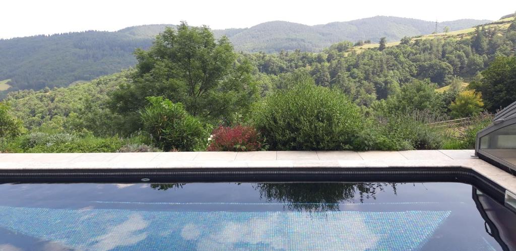una piscina con vista sulle montagne di Bâtisse Ardechoise avec piscine a Saint-Prix