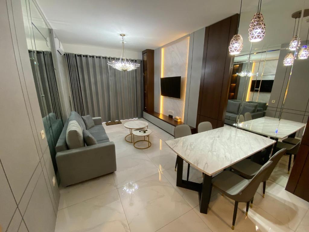 a living room with a table and a couch at Sky House BSD in Samporo