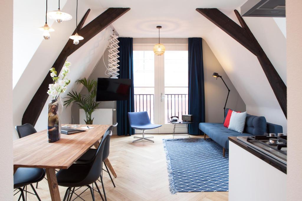 een woonkamer met een tafel en een blauwe bank bij The Duke Boutique Apartments in Den Bosch