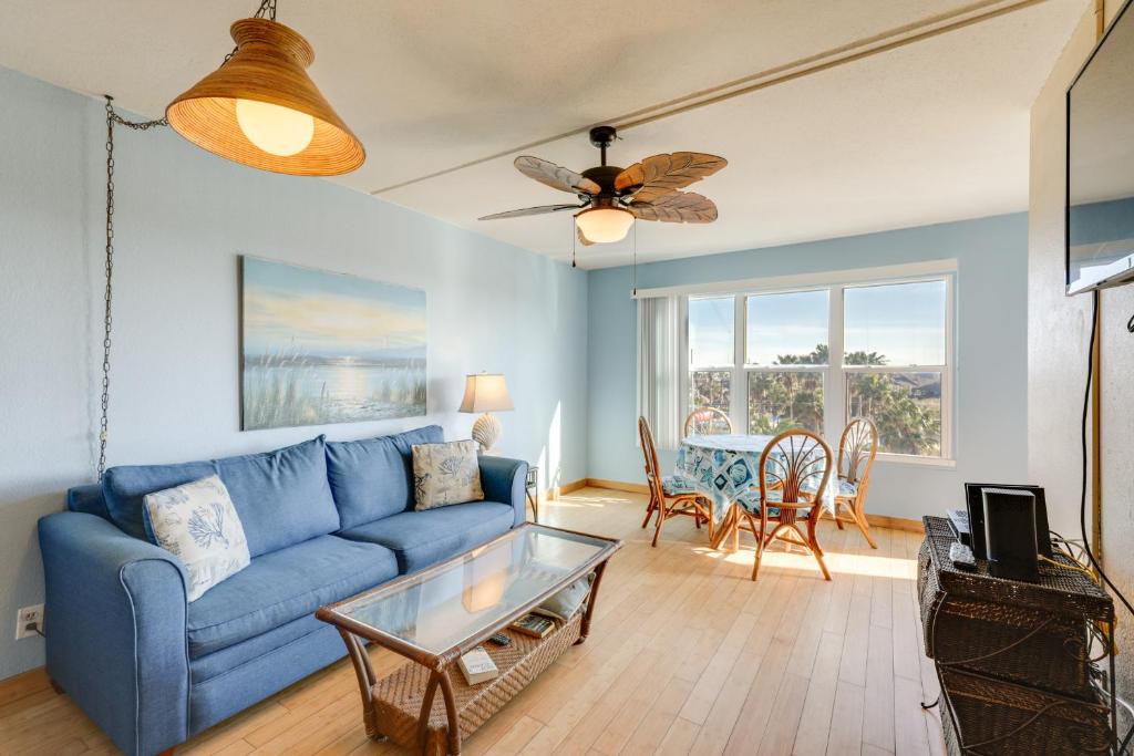 un salon avec un canapé bleu et une table dans l'établissement South Padre Island Condo - Walk to Beaches!, à South Padre Island
