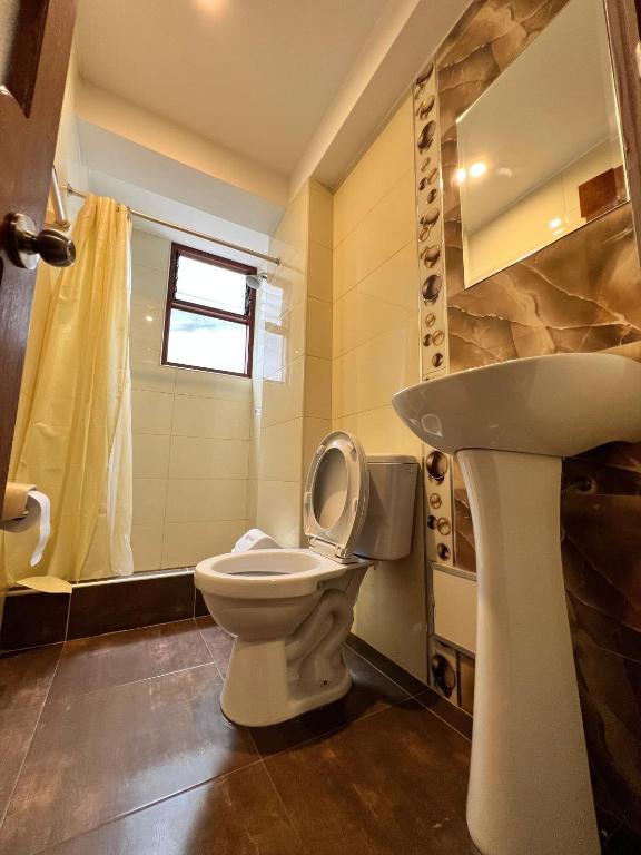 un bagno con un water e un lavandino di HAYLLI QOSQO Hotel Inn a Cuzco