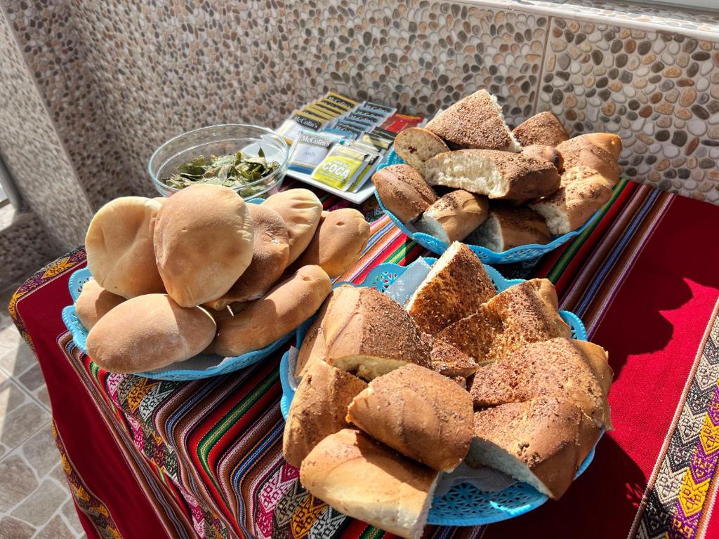un tavolo ricoperto di cesti di pane e panini di HAYLLI QOSQO Hotel Inn a Cuzco