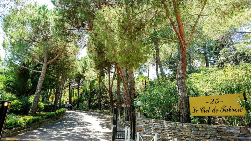 un chemin dans un parc arboré et un panneau dans l'établissement Condo in a private residence with pool, à Nice