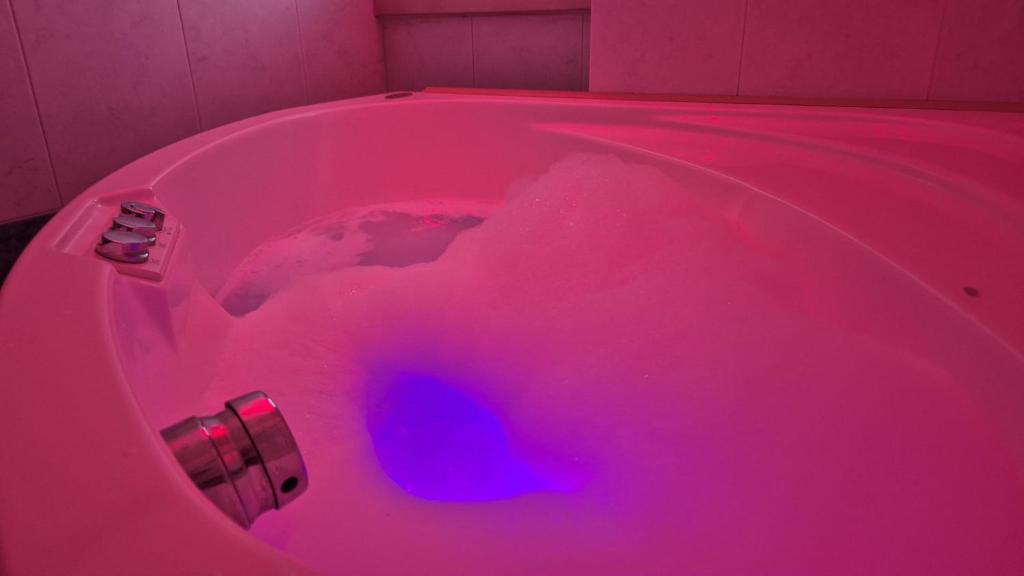 a pink bath tub filled with red dye at Spazio Prestige in Milan
