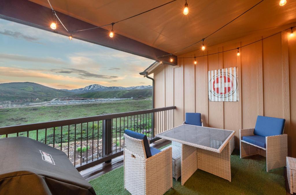 a porch with a table and chairs on a balcony at Minutes to Deer Valley and Park City, Private Hot Tub, Mountain Views, Living + Family, More in Heber City