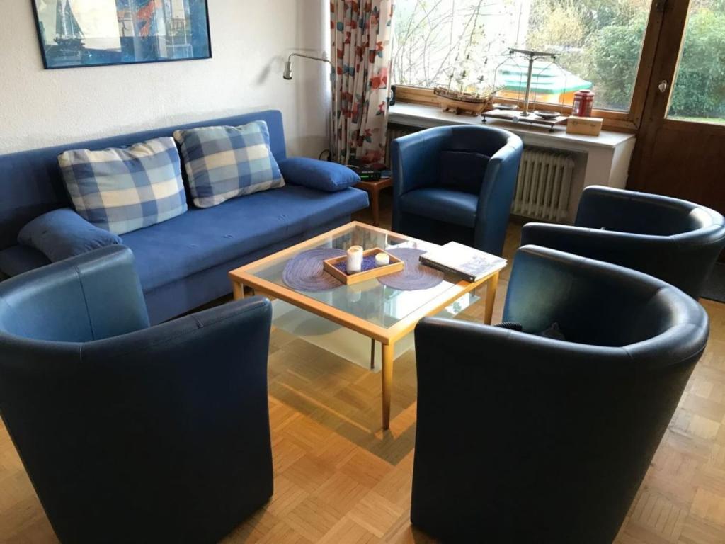 a living room with a blue couch and chairs at Nice holiday home near the centre in Duhnen