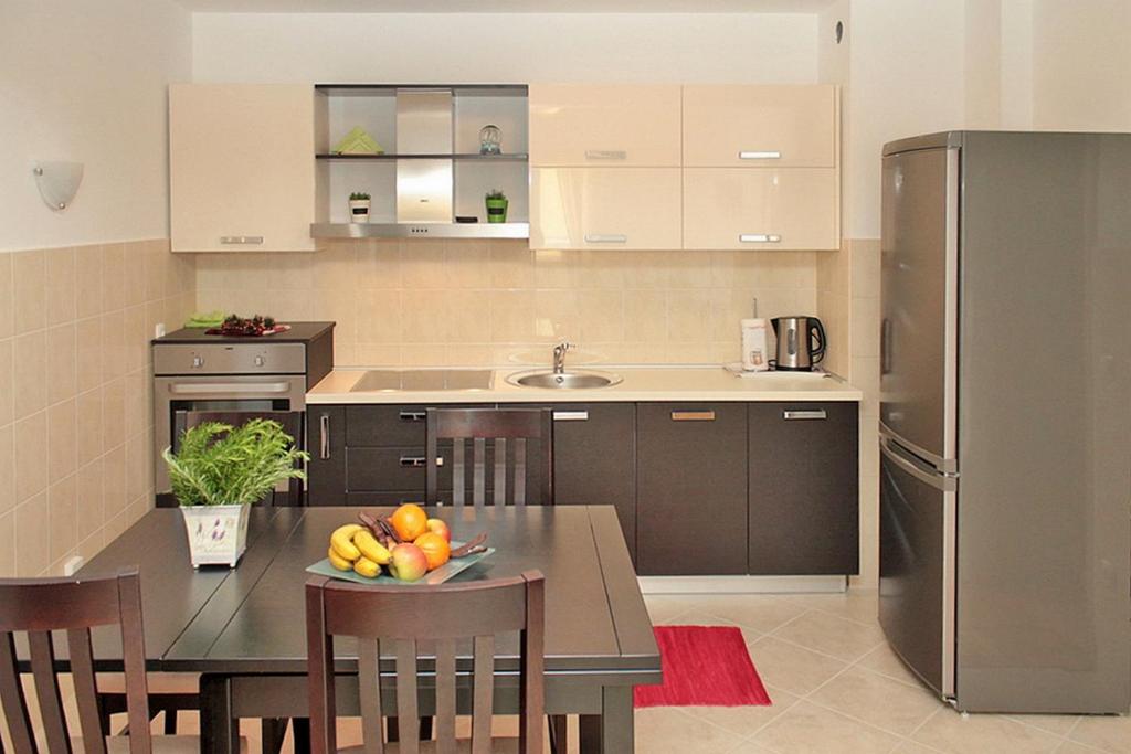 una cocina con una mesa con un bol de fruta. en Apartment Central City, en Makarska