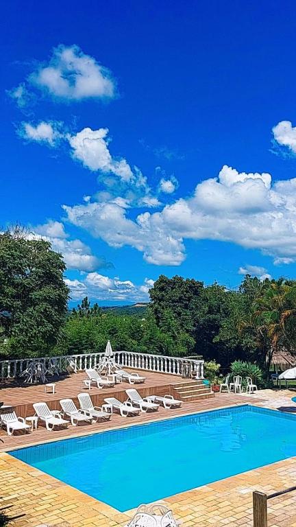a large swimming pool with lounge chairs at Pousada Aconchego de Minas in Juiz de Fora