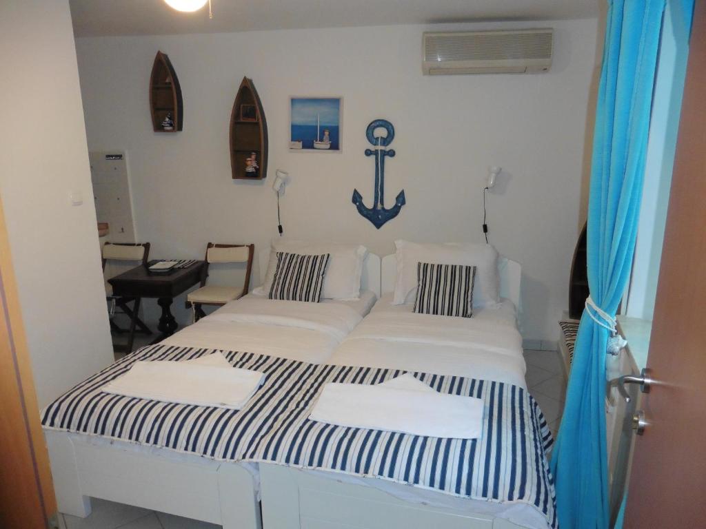 1 dormitorio con 2 camas y un ancla en la pared en Room Leon, en Split