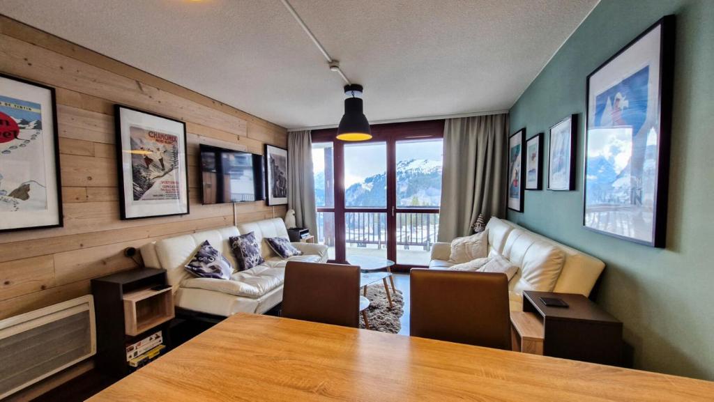 un salon avec une table et un canapé dans l'établissement Résidence Le Panoramic - Appartement spacieux · Départ et retour skis aux pieds · Piscine · Parking inclus · Spa MAE-6931, à Magland