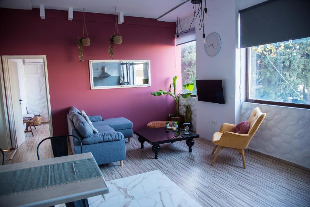 a living room with a blue couch and chairs at mandala central apartment in Rhodes Town